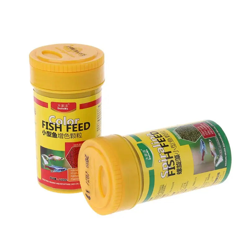 Two yellow plastic jars of small, granular fish feed with colourful aquarium fish imagery on the labels.