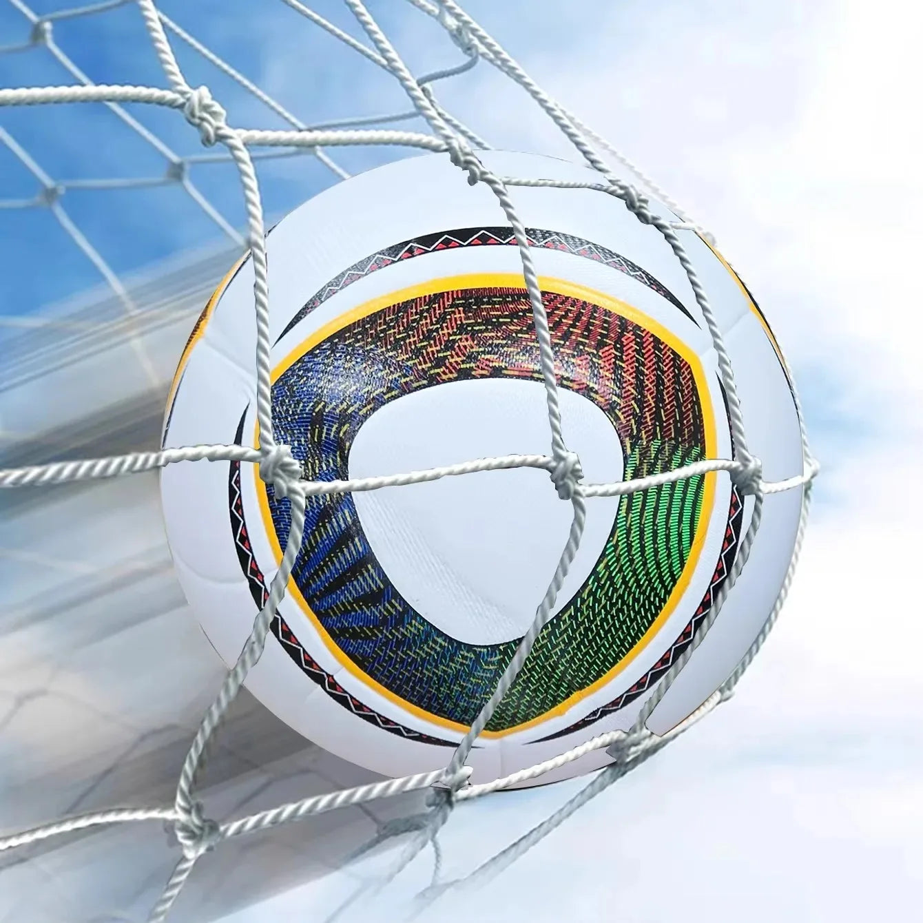 White football with multi-coloured geometric patterns, caught in a goal net against a bright sky.