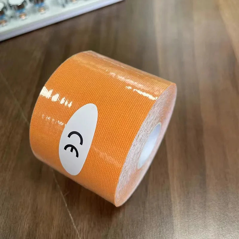 A roll of orange kinesiology sports tape with a CE mark sticker, positioned on a wooden surface.