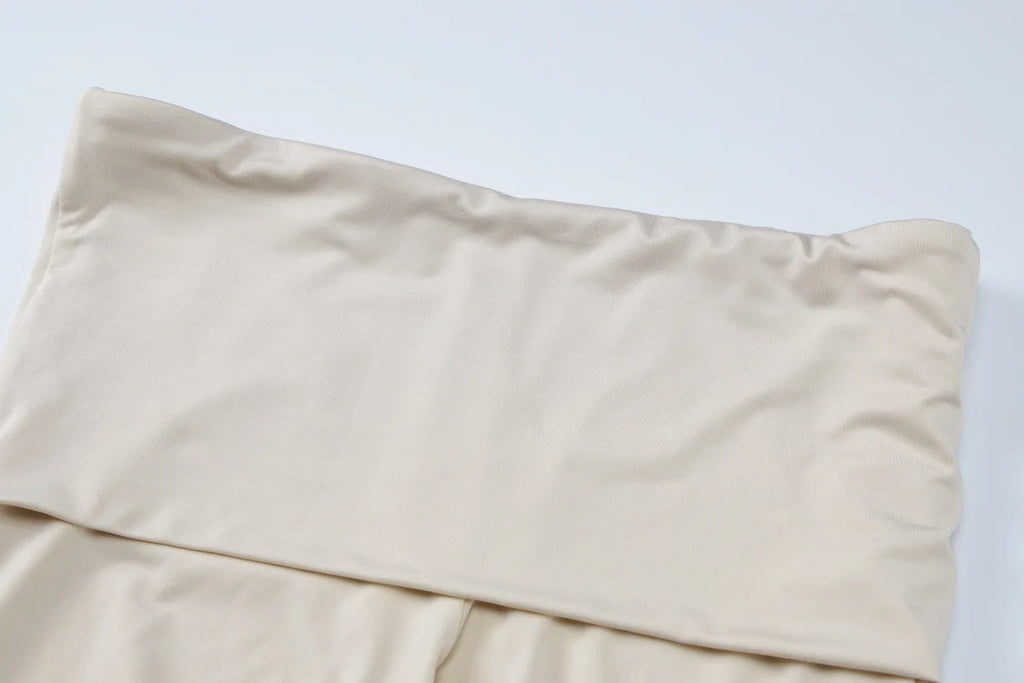 Beige high-waisted leggings featuring a wide, fold-over waistband for a smooth, supportive fit.