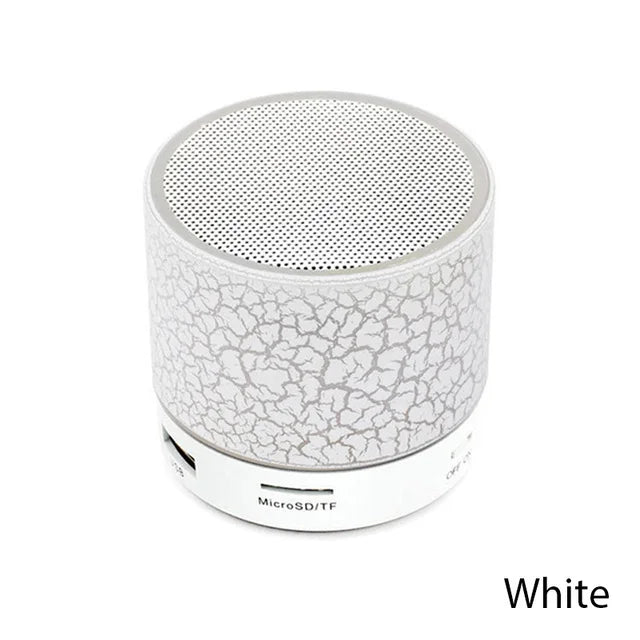 A white portable mini wireless Bluetooth speaker featuring a cracked-effect design and a metal mesh top.