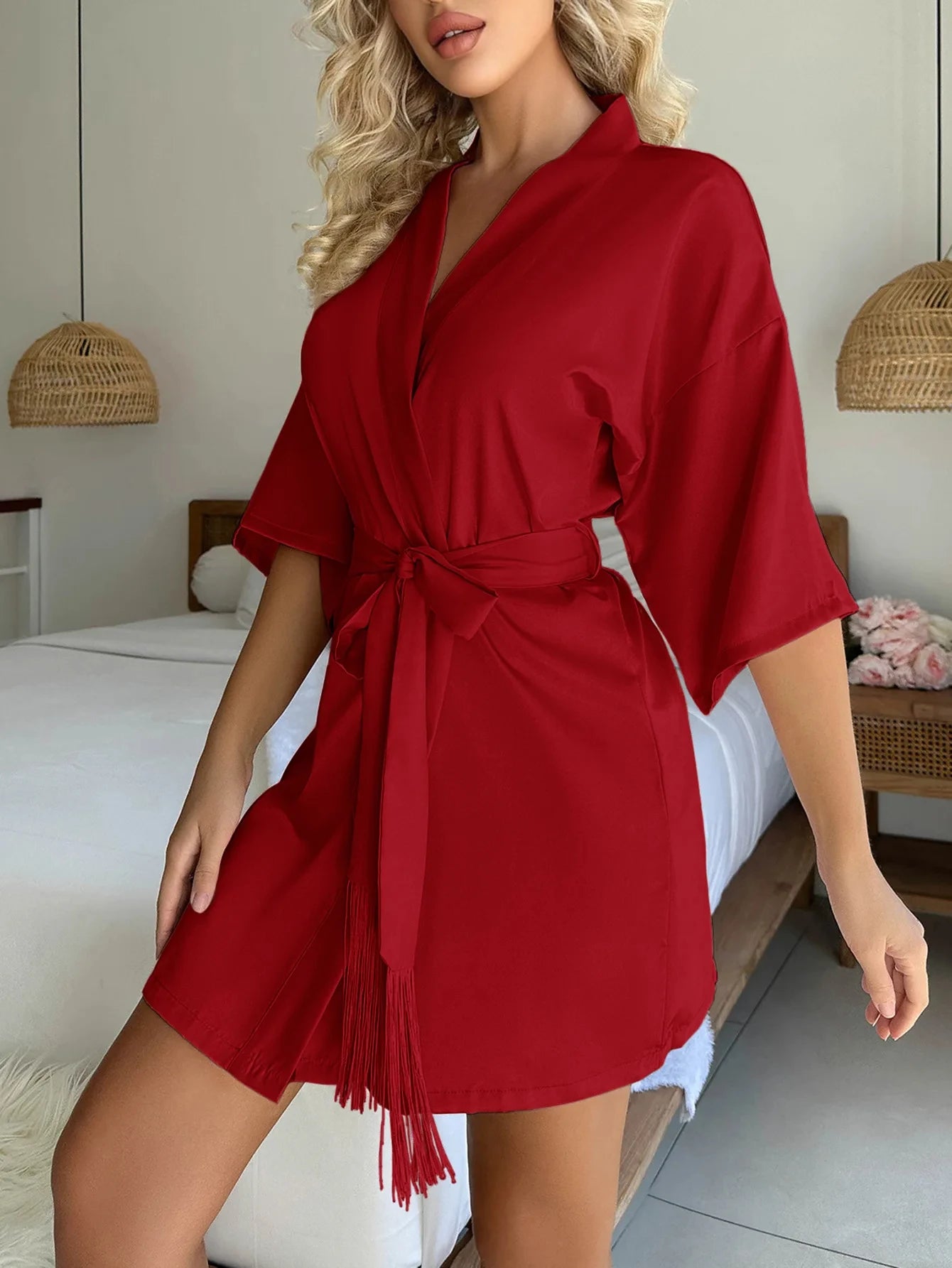 A short, red satin robe featuring a wrap front, kimono-style sleeves, and a matching tie waist belt.