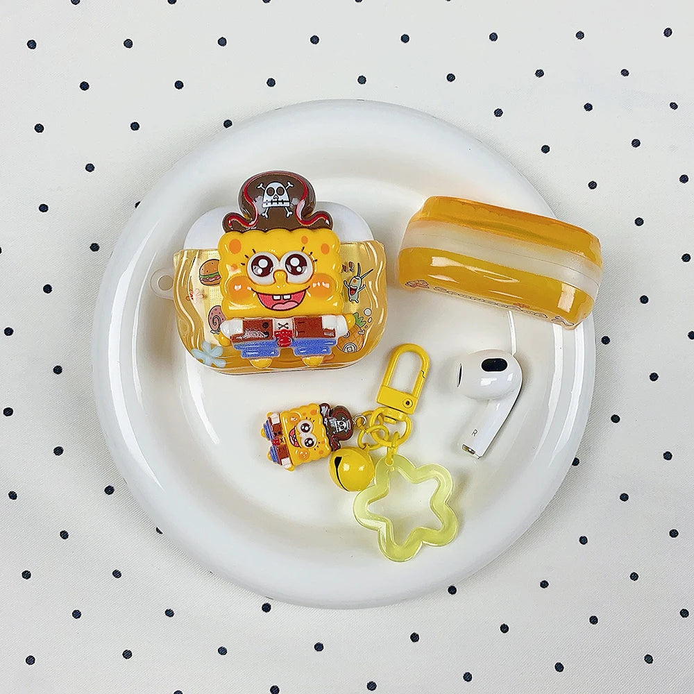 Yellow silicone SpongeBob pirate AirPods Pro case with matching charm, keyring, and star accessory on a white plate.