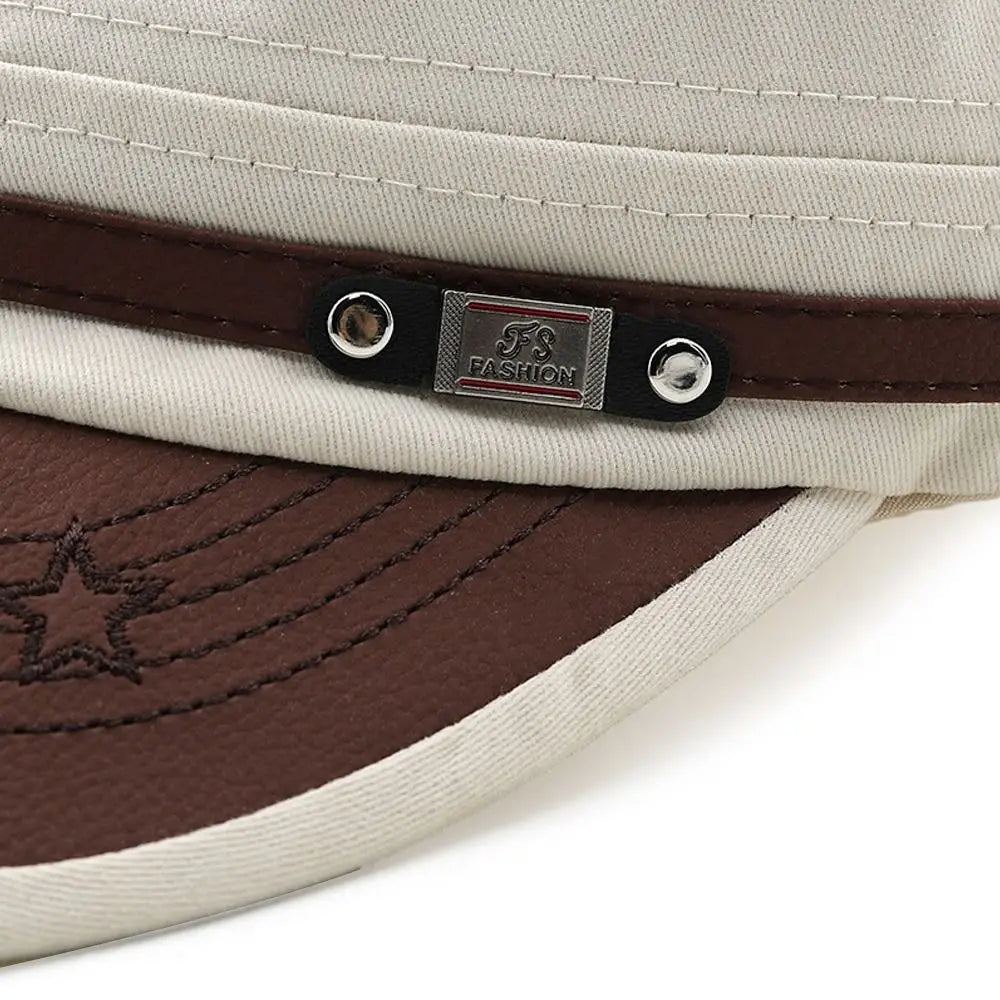 Close-up of a cream-coloured cadet cap with a brown faux-leather peak, star detail, and brown strap trim.