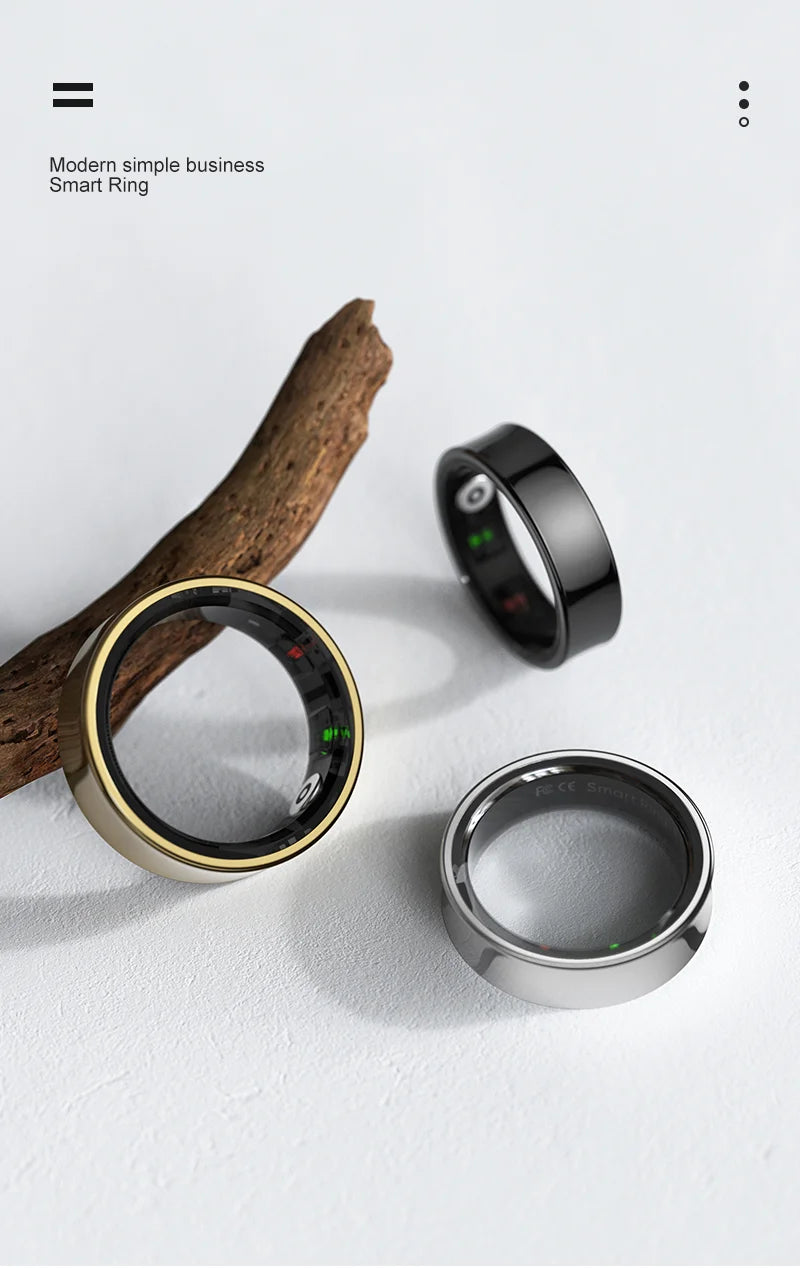 Three sleek smart rings in black, gold, and silver, showing health sensors on a white background with a piece of wood.