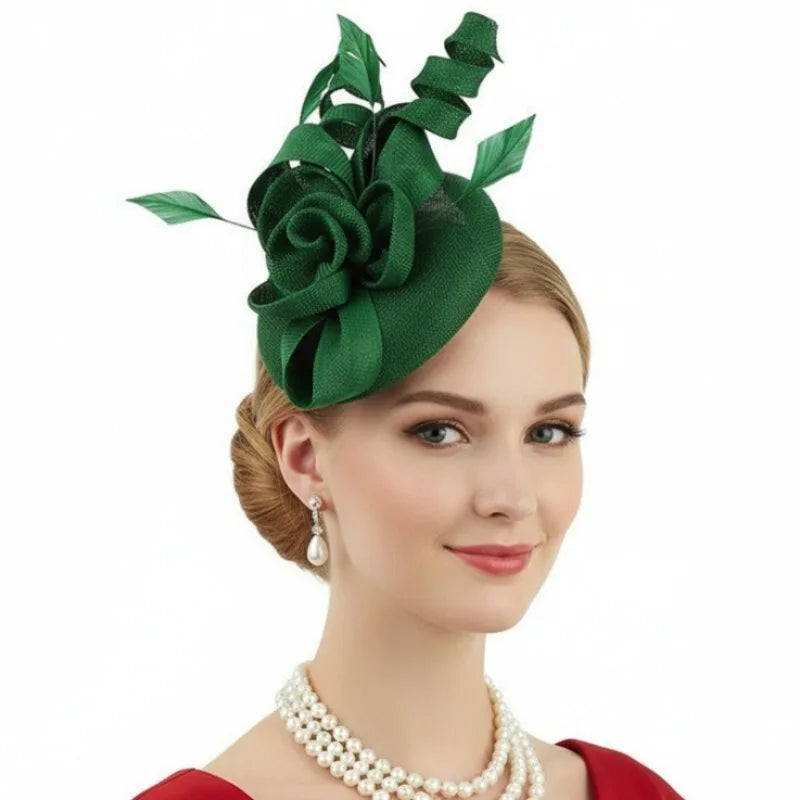 A woman wearing an elegant dark green fascinator hat with a large fabric flower, curled ribbon and feather accents.
