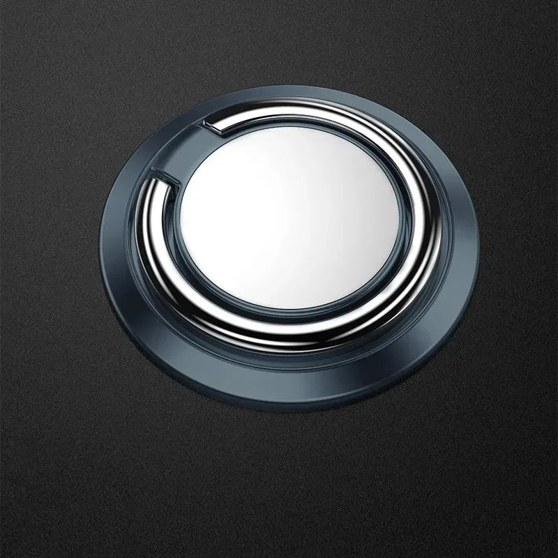 A circular dark grey phone ring holder with a polished silver metallic ring, set against a matching dark background.