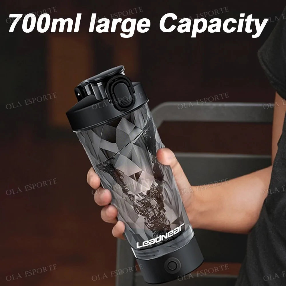 A 700ml black shaker bottle with a geometric, faceted design, held in a hand against a dark background.