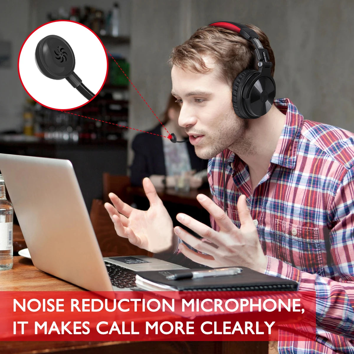 Man wearing black and red wireless gaming headphones with a noise-cancelling microphone while using a laptop.