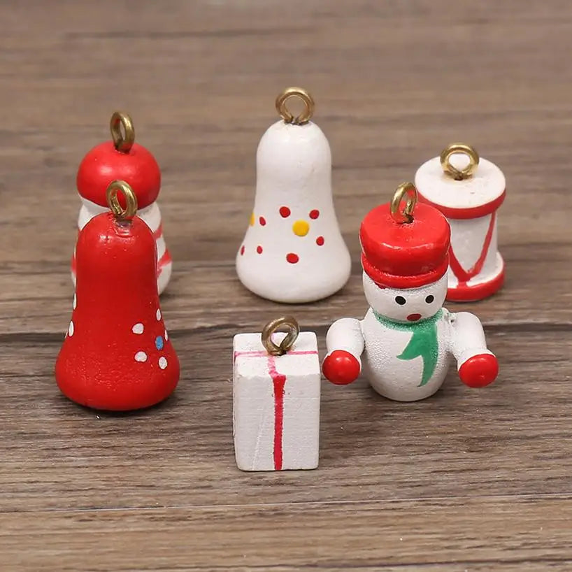 Set of six small, hand-painted wooden Christmas tree ornaments including bells, a snowman, and a gift parcel.