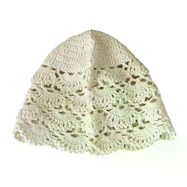 Cream-coloured women’s beanie hat in a delicate hollow crochet lace design with a scalloped pattern.