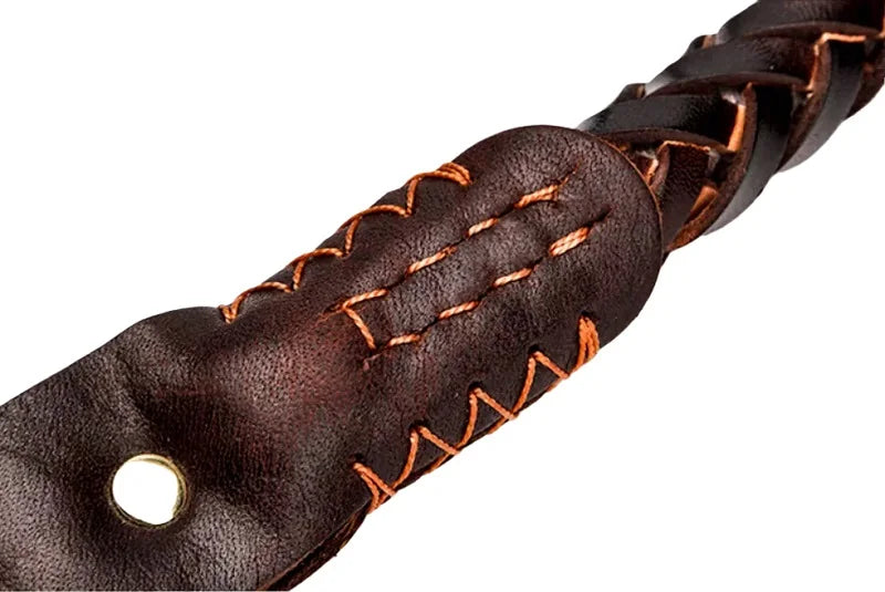 Close-up of a dark brown braided leather dog collar featuring durable orange contrast stitching and a brass eyelet.