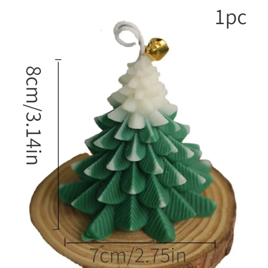 Festive green and white Christmas tree candle with a small gold bell detail, standing on a wooden base.