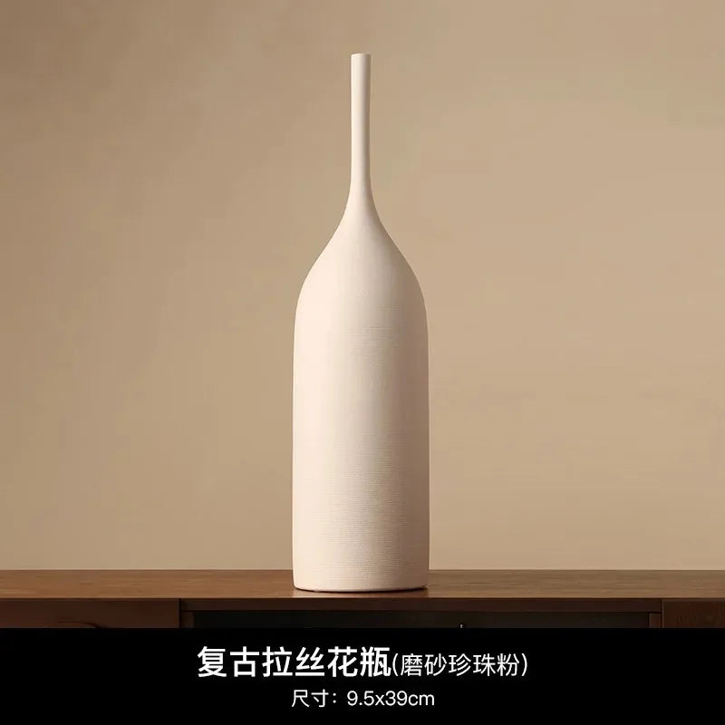 Tall, slender cream ceramic vase with a matte, textured finish and minimalist wabi-sabi aesthetic.