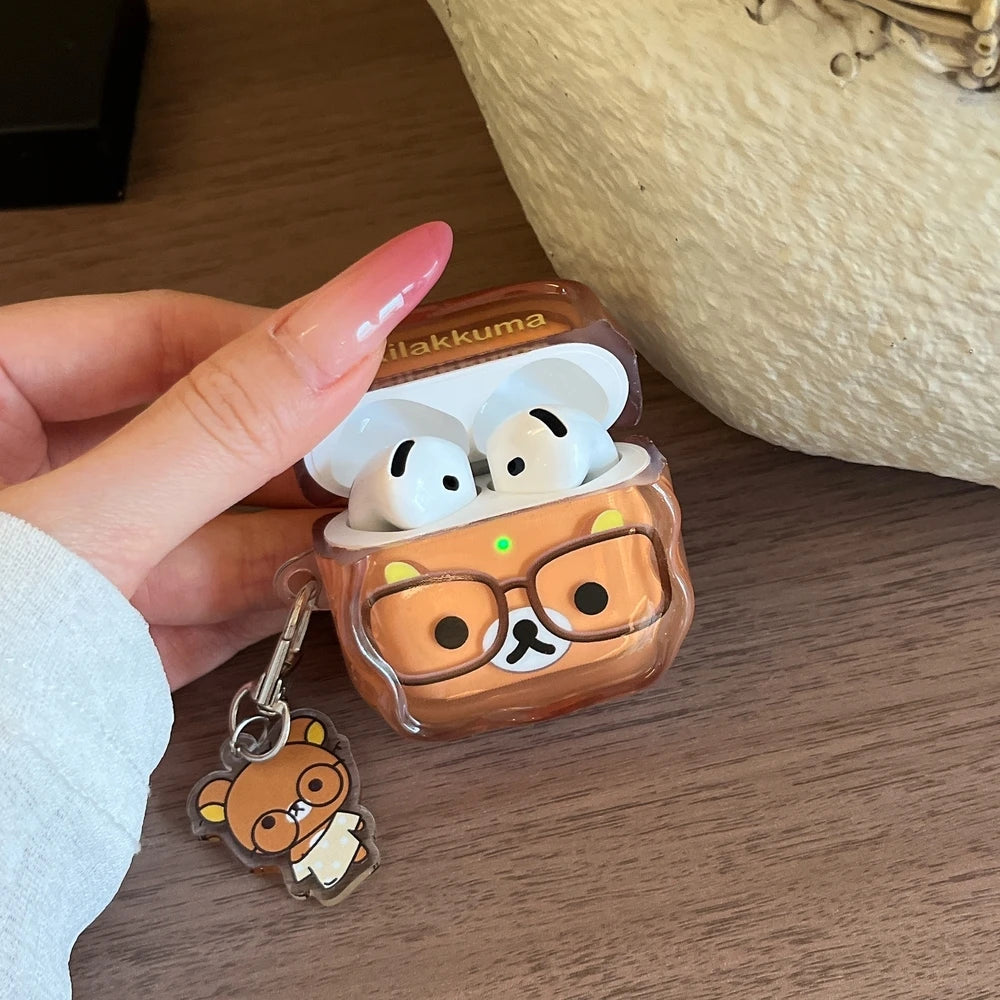 Clear brown Rilakkuma AirPods case with matching charm, featuring a cartoon bear design with glasses.