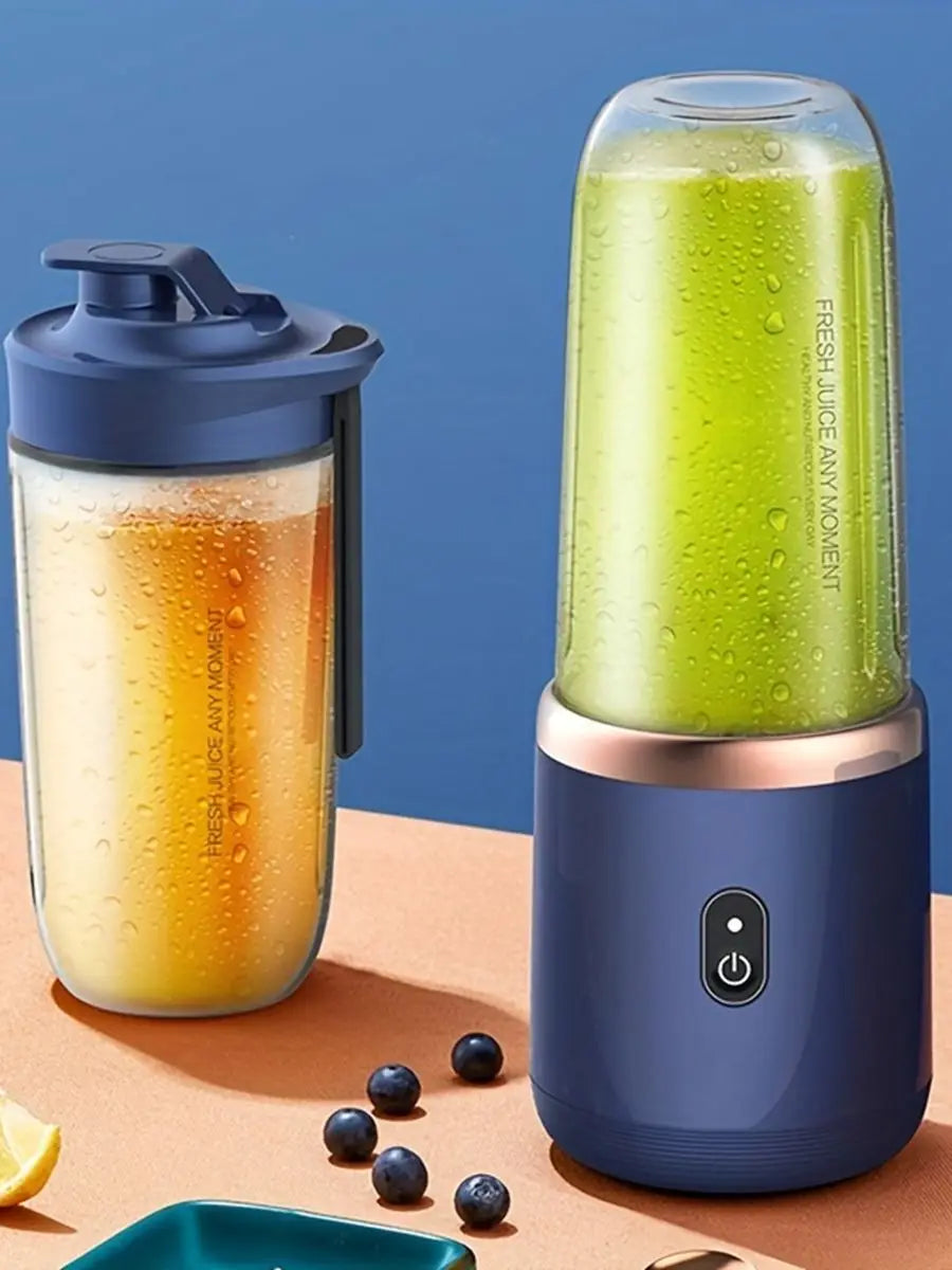 Two portable blue blenders with clear, condensation-covered containers holding juice, placed on an orange surface.