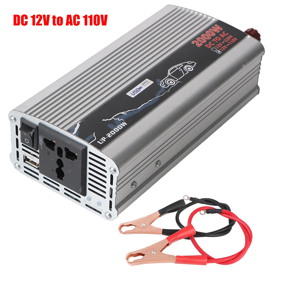 Silver 2000W DC to AC power inverter with USB port, AC outlet, power switch, and included red and black battery clips.