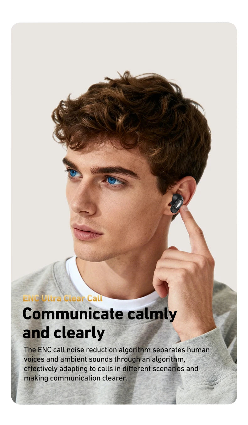 Young man wearing a sleek, black wireless earbud in his left ear while touching it. Plain light background.