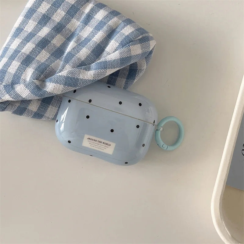 Glossy light blue polka dot AirPods Pro case with a matching side ring and 'Around the World' label.