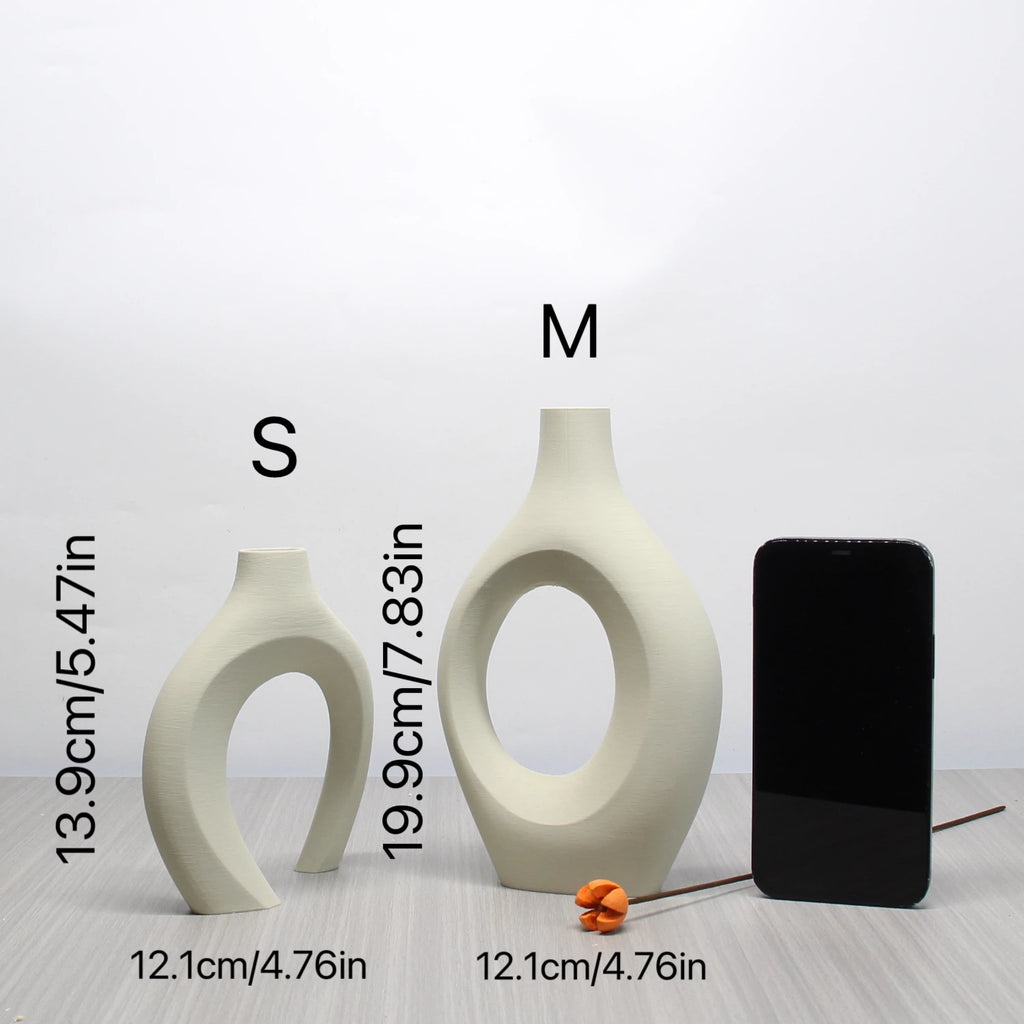 Two cream-coloured, abstract Bohemian-style vases with cut-out centres, shown in small and medium sizes.
