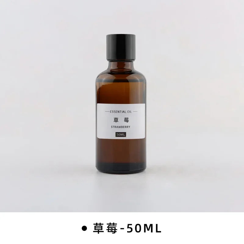 50ml amber glass bottle of strawberry essential oil with a black screw cap and minimalist white label.