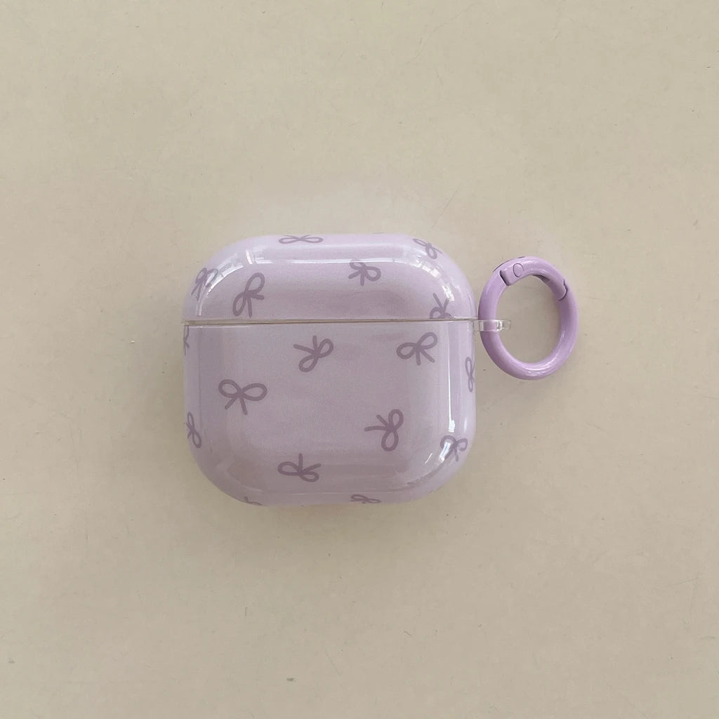 Glossy lilac AirPods 3 case with a bow pattern and matching ring carabiner.