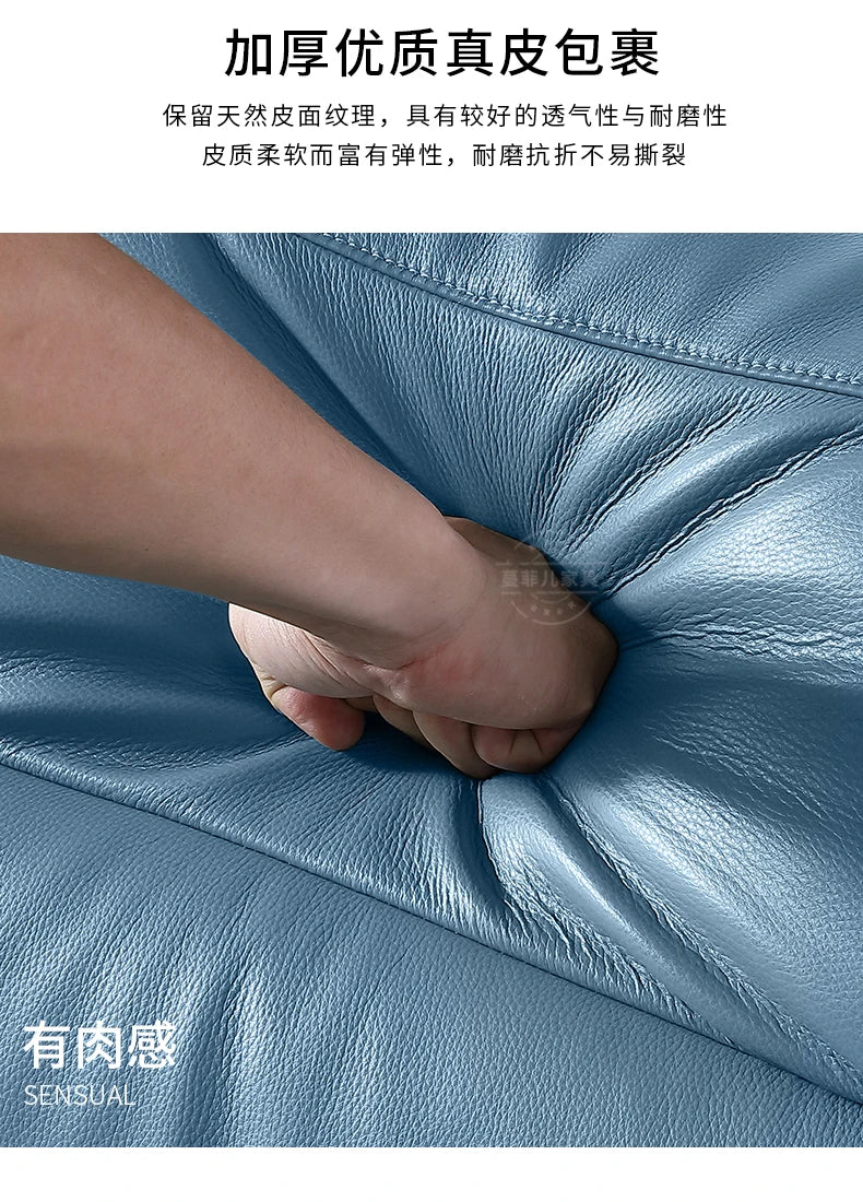Close-up of a hand pressing into the soft, blue leather padded headboard of a modern storage double bed.