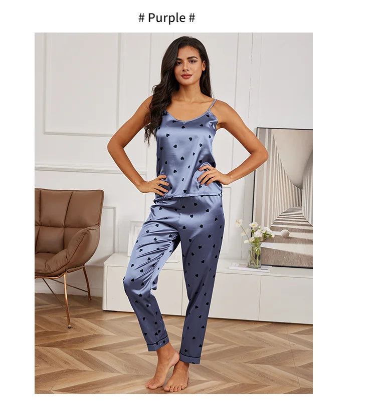 Purple satin pyjama set featuring a camisole top with thin straps and matching trousers, all with a black heart print.