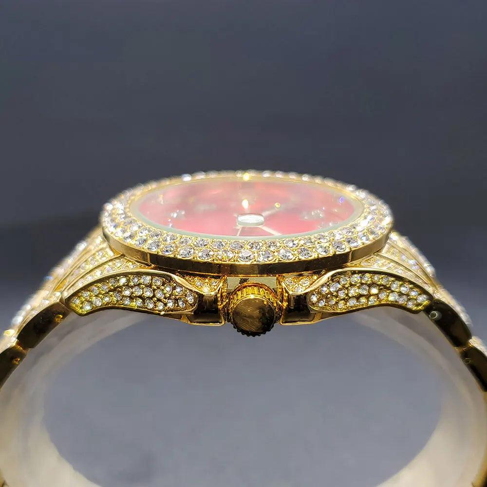 Side view of an elegant gold-toned watch featuring a vibrant red face and diamond-accented bezel and strap.