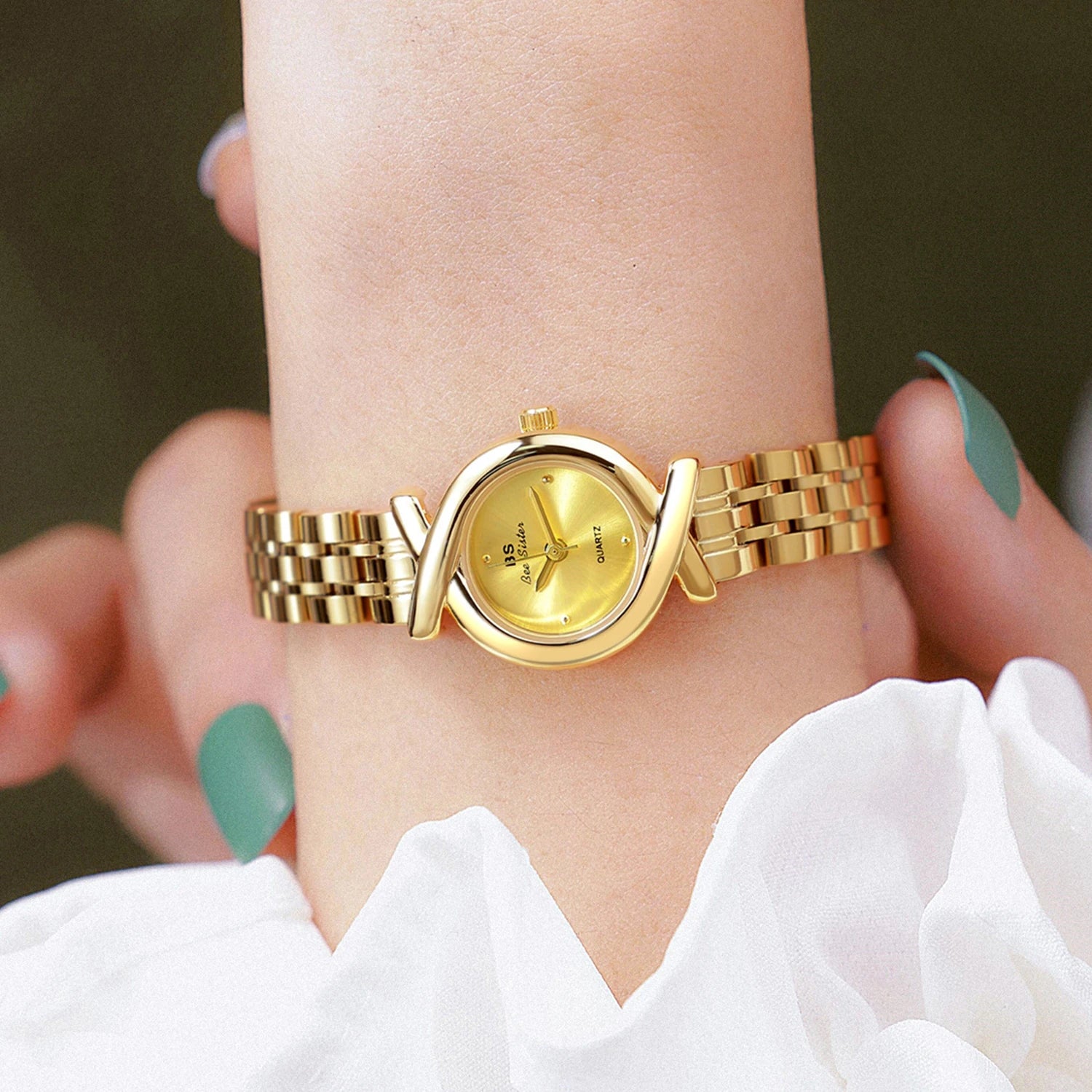 Elegant gold-tone women’s quartz wristwatch with a decorative crossover bezel and a polished stainless steel link strap.