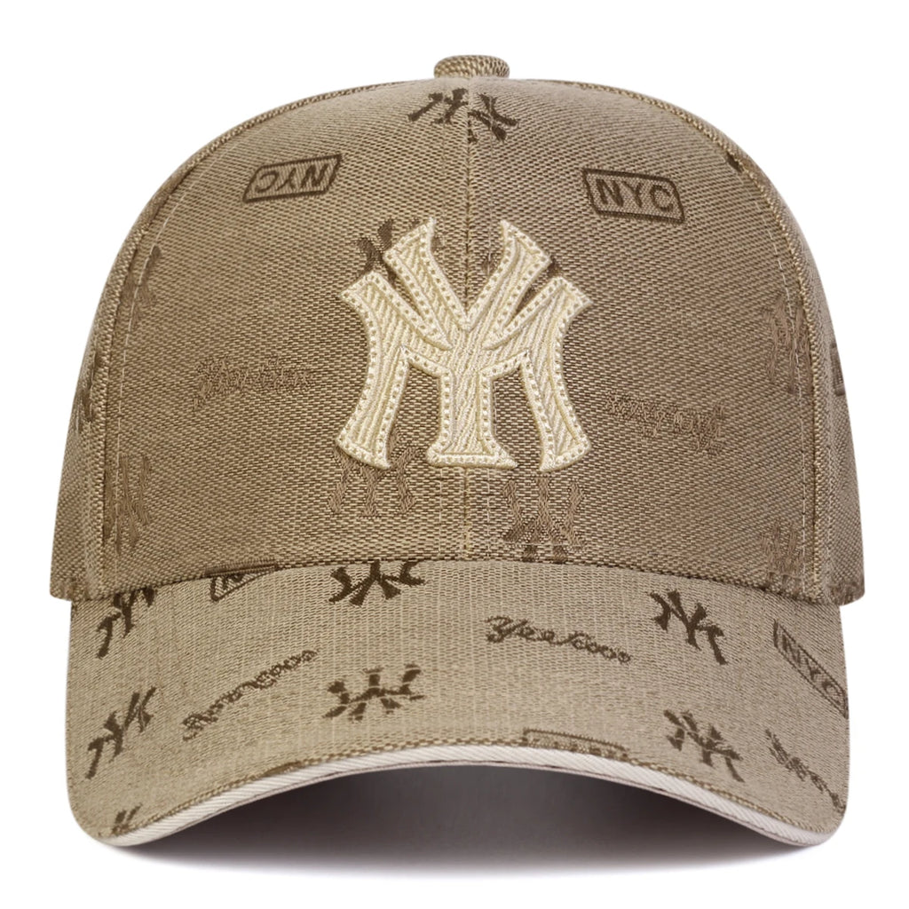 Beige unisex baseball cap with a large central "MY" monogram and an all-over small pattern of logos and "NYC" text.