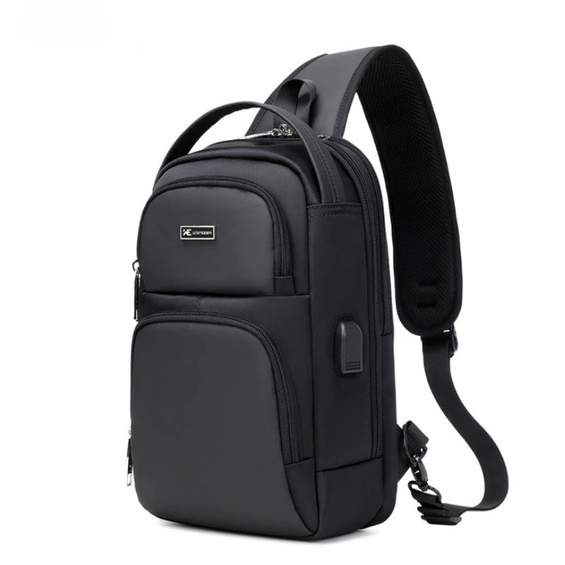 Black waterproof sling bag with padded shoulder strap, multiple zip compartments, and a side USB charging port.