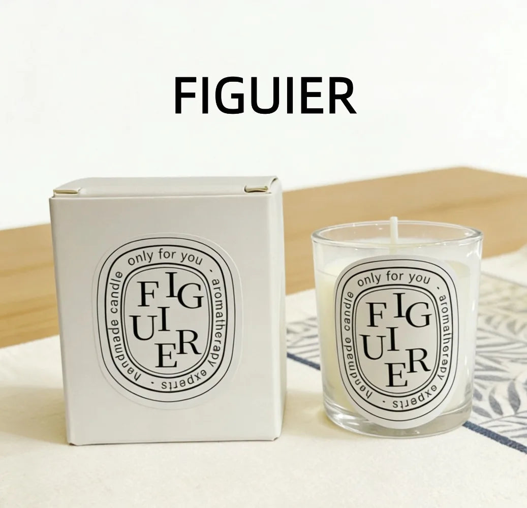Figuier scented candle in a glass holder next to its white cardboard gift box, featuring a minimalist black-on-white label.