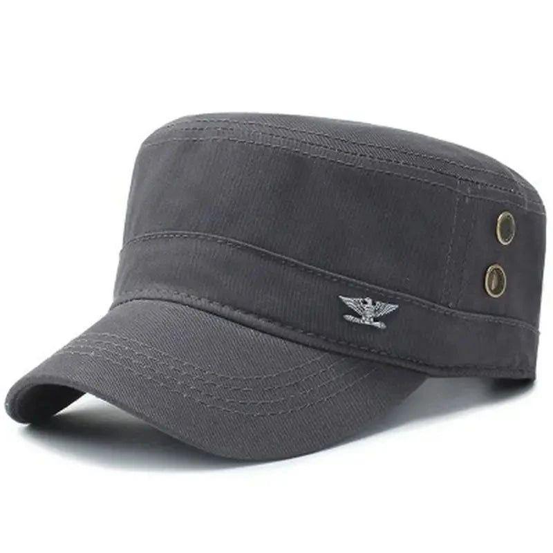 Dark grey military-style flat-top cap featuring a small silver eagle emblem and metallic side eyelet details.