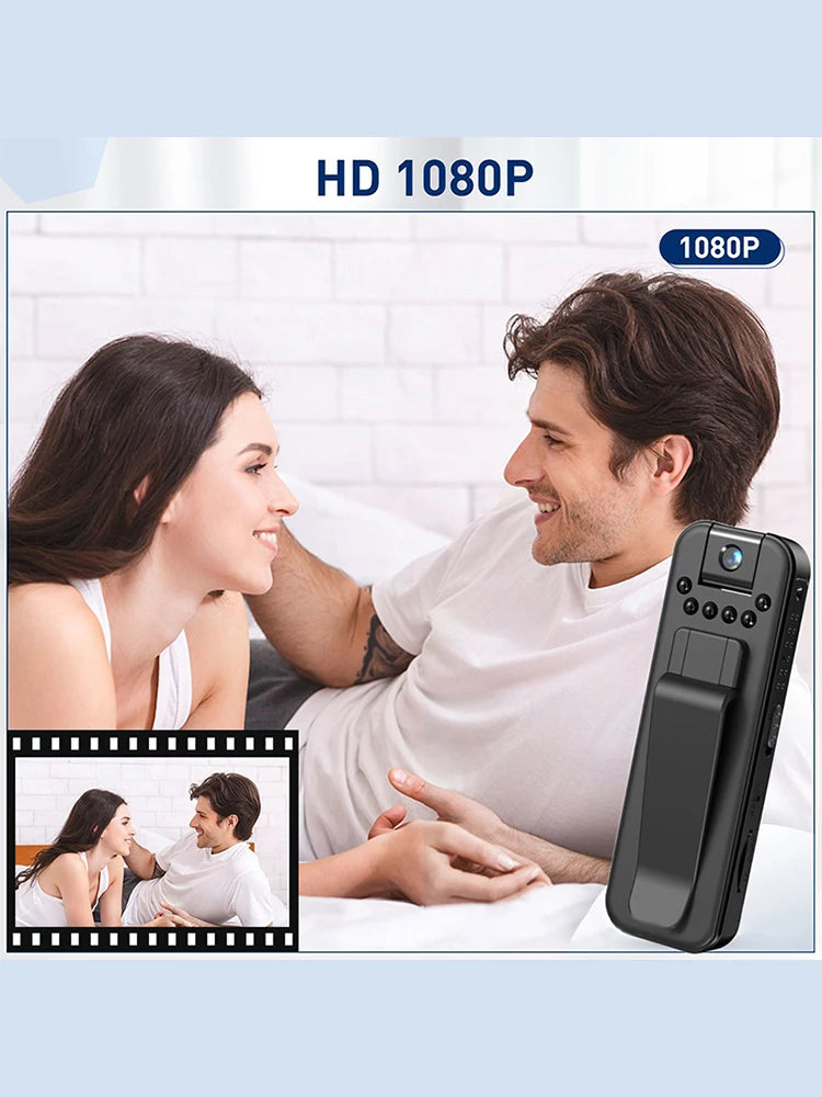 Black portable 1080p HD wearable video camera with a belt clip, shown next to a couple relaxing in bed.