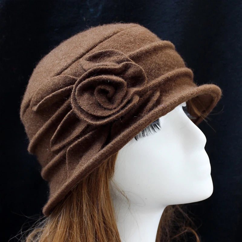 Elegant brown wool winter hat with a decorative side flower and ruched detailing, shown on a mannequin head.
