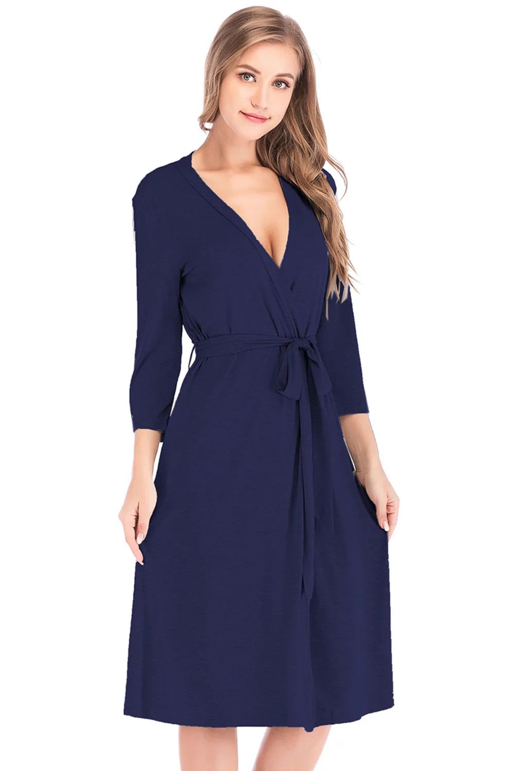 A woman wearing a navy blue knee-length wrap robe with three-quarter sleeves and a waist-tie belt.