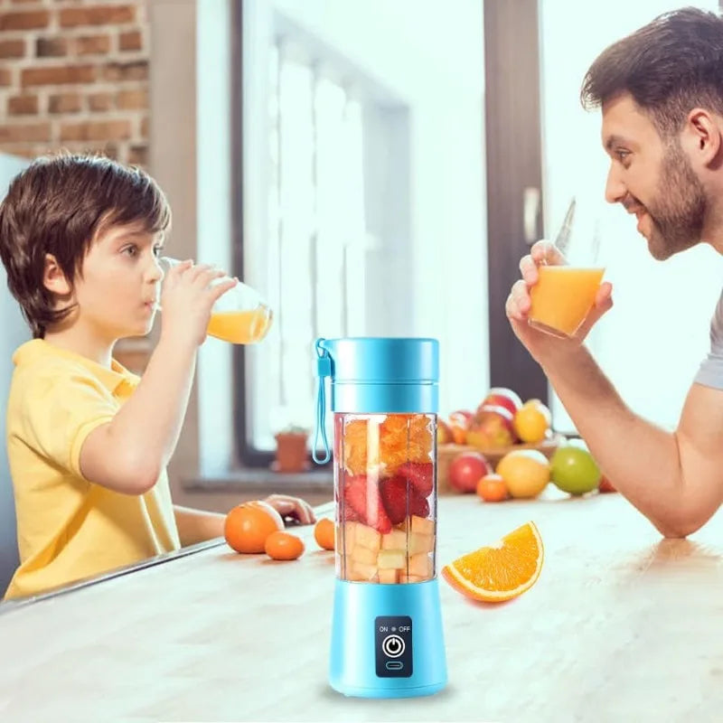 A portable, sky-blue cylindrical smoothie blender with a transparent center, shown on a kitchen counter with fruit.
