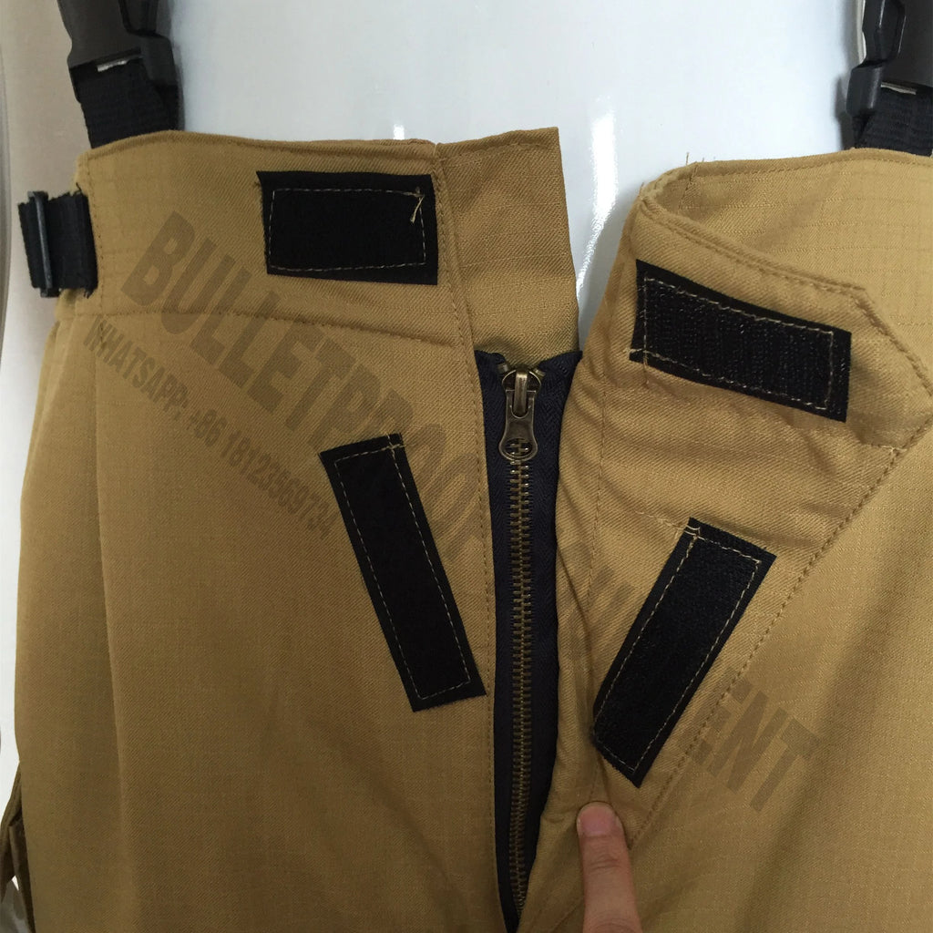 Tan tactical pants featuring a zippered fly, adjustable straps, and black hook-and-loop closures.
