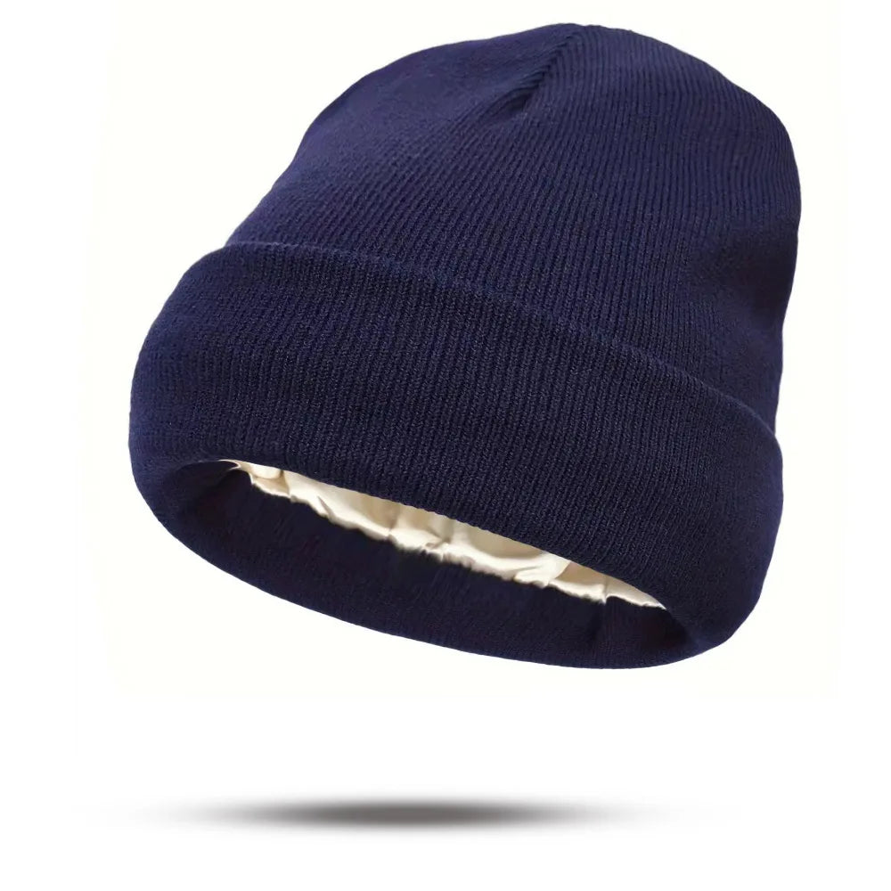 Navy blue knitted winter beanie with a cream-coloured satin lining, featuring a classic turn-up cuff.