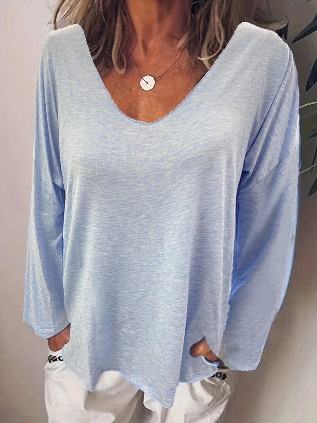 Light blue, long-sleeved, oversized V-neck top in a soft marl fabric with front pocket detail.