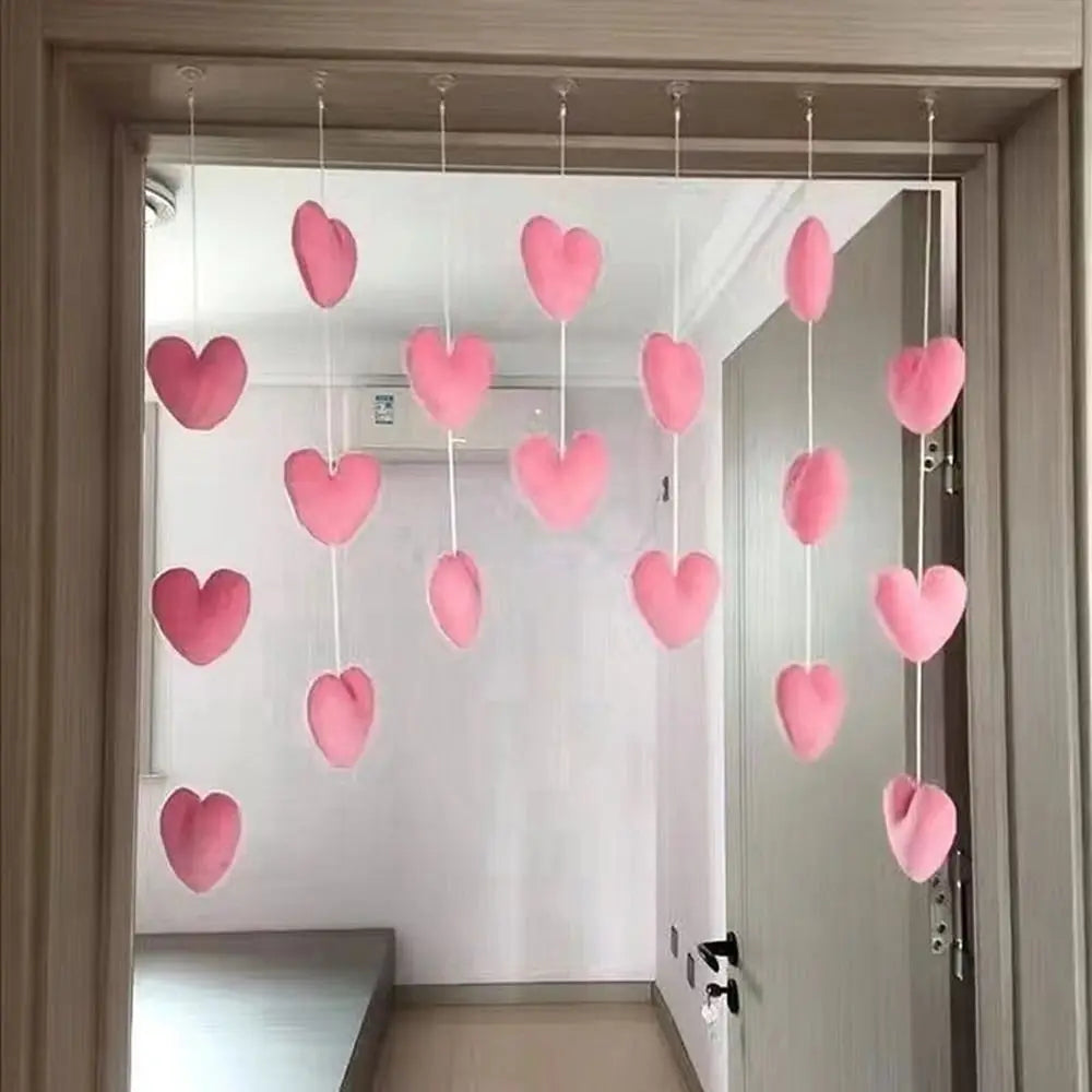 Decorative hanging door curtain featuring rows of soft, blush-pink fabric hearts on white strings.