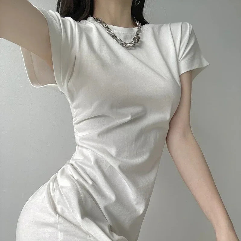 White short-sleeved mini dress with side ruching and crew neckline, featuring a fitted, modern silhouette.