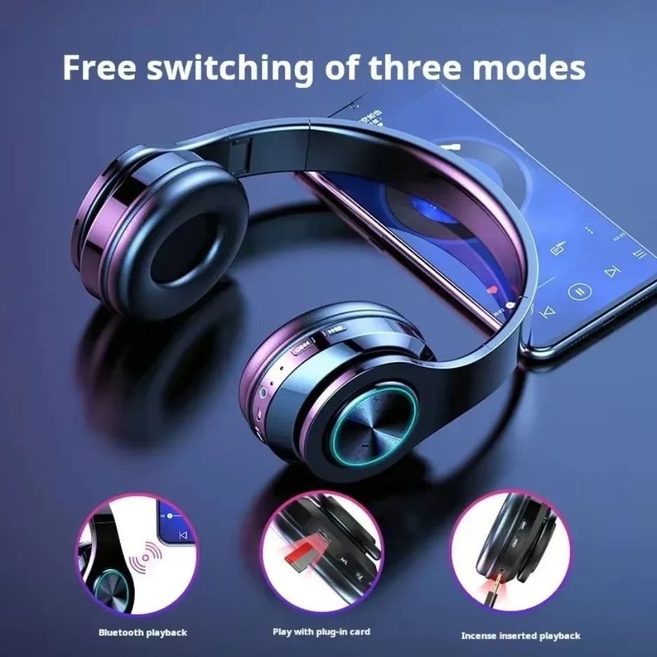 Black and purple wireless gaming headset featuring glowing LED rings, side playback controls, and multiple input modes.
