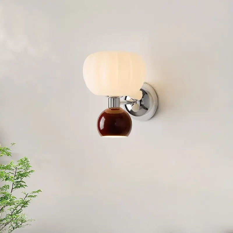 Contemporary cream and brown wall lamp with two rounded, glass shades on a polished chrome fixture.