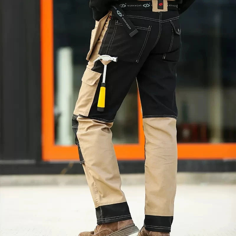 Men's black and beige two-tone cargo work trousers with multi-functional utility pockets and tool storage.