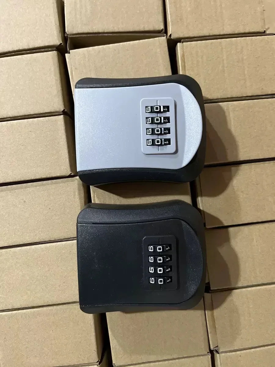 Two wall-mounted metal key lock boxes in grey and black, each featuring a four-digit combination dial.