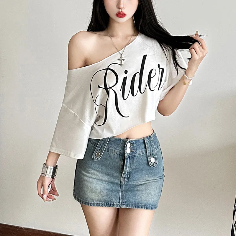 White oversized crop t-shirt with a skew collar, short sleeves, and black "Rider" letter print.