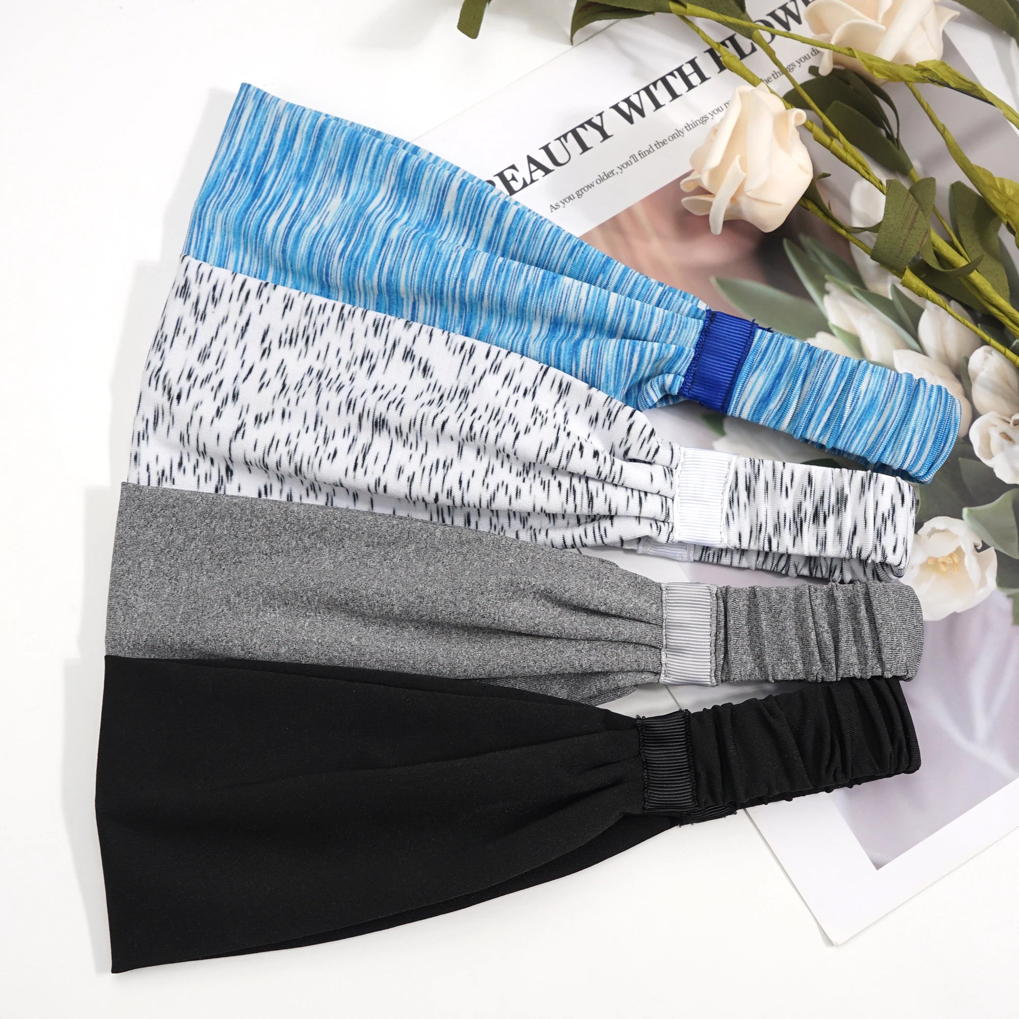 Set of four elasticated headbands in blue, speckled white, grey, and black, featuring gathered fabric and ribbon detail.