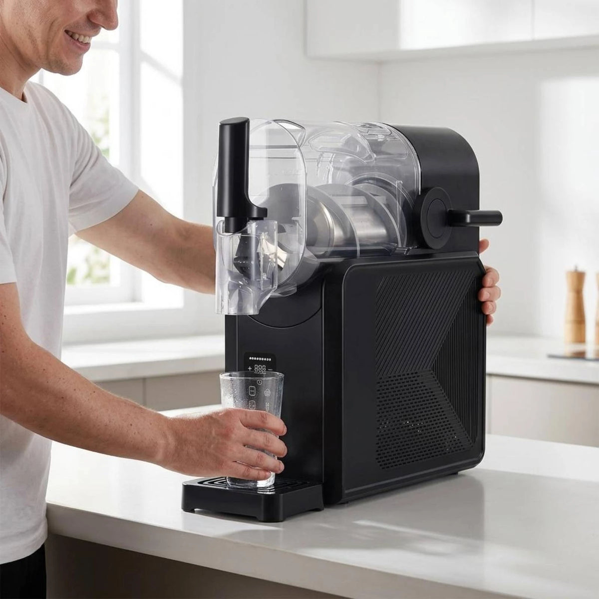 Black countertop slush machine with a clear tank, dispensing handle, and digital display, being used in a kitchen.